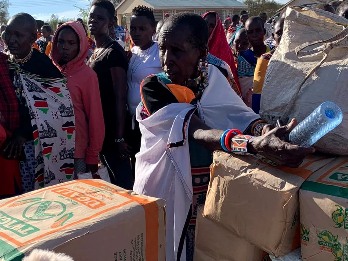 Community members gathered around education support boxes during a CYEF resource delivery
