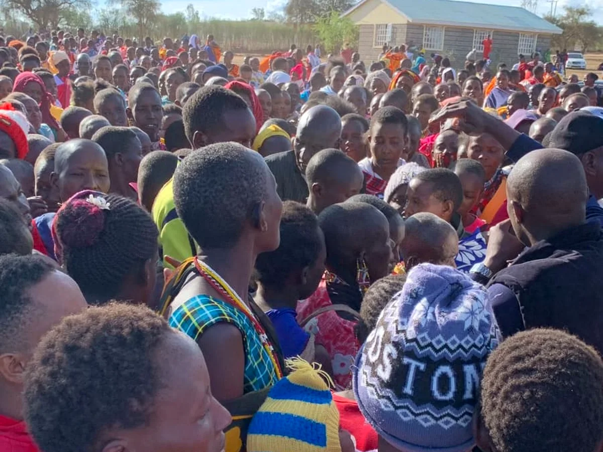 A large group of children and community members gathered during an education support activity