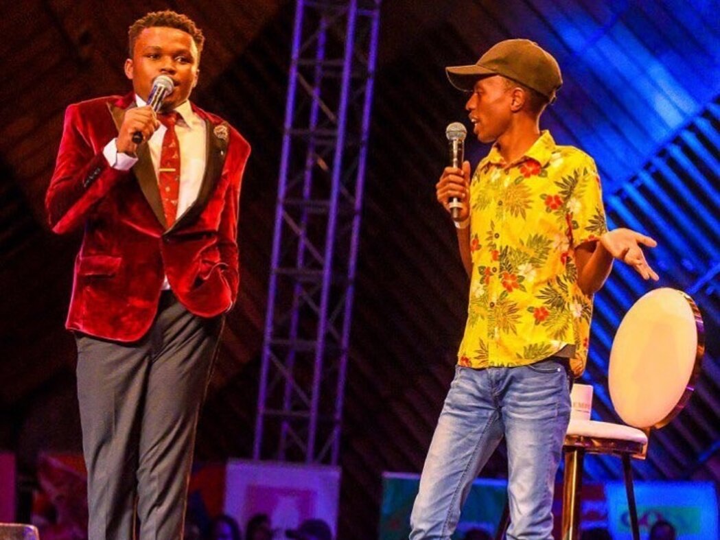 Two comedians performing on stage with microphones