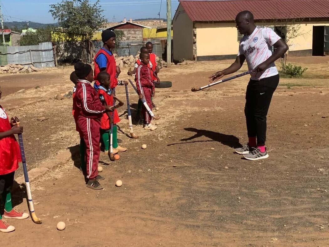 A coach guiding St. Martin De Porres hockey players during a training session